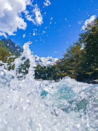 Low angle view of waterfall against sky during winter