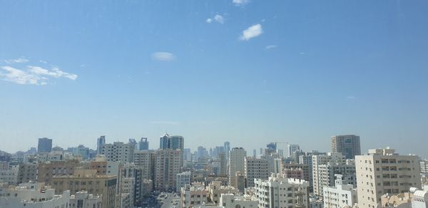 Buildings in city against blue sky