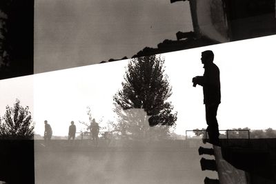 Man standing by tree against sky