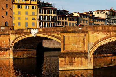 Ponte santa trinita over arno river in tuscany against sky