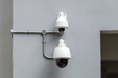 Close-up of security cameras mounted on wall