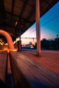 Blurred motion of illuminated train against sky at sunset