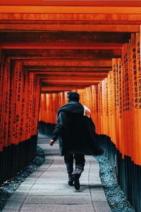 Rear view of man walking on red road