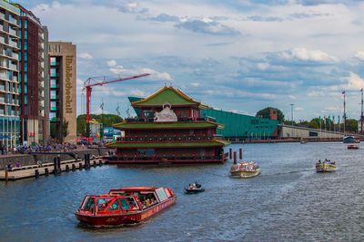 Boat in river against buildings