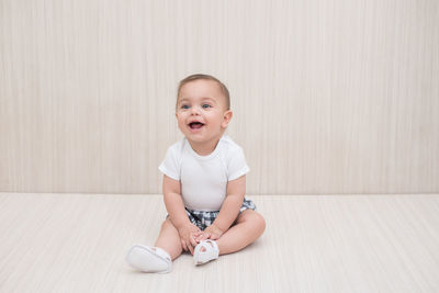 Portrait of happy boy sitting on floor