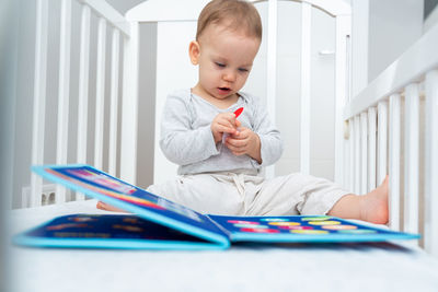 Cute girl playing with toy on bed at home