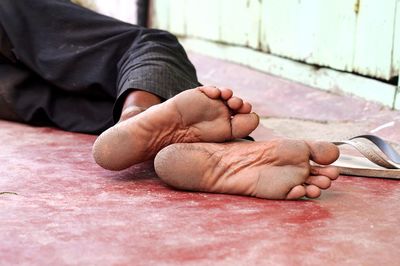 Low section of man lying on sidewalk
