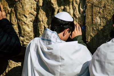 Rear view of man and woman standing on rock