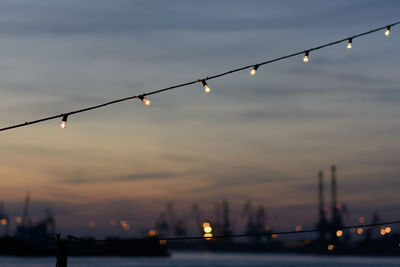 Close-up of illuminated pole against sky at dusk