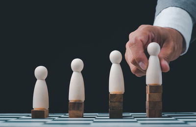 Close-up of white hands on table against black background