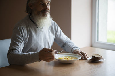 Midsection of man holding food on table at home