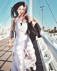 Portrait of beautiful woman walking on bridge