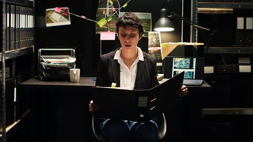 Side view of woman using digital tablet while sitting on table