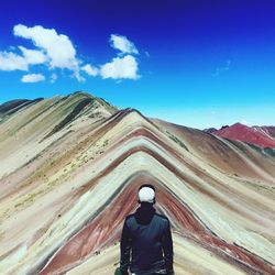 Rear view of man on mountain against sky