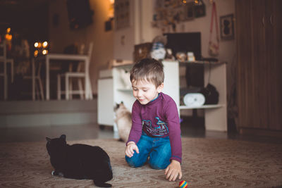 Boy playing with cat at home