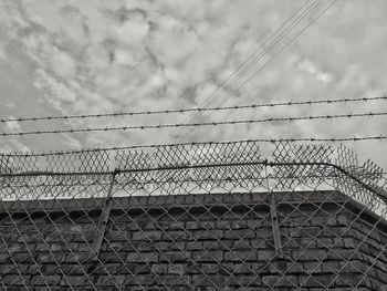 Low angle view of chainlink fence against sky