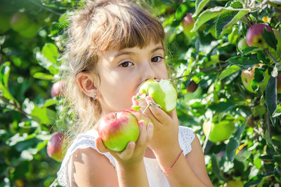 Portrait of young woman holding apple