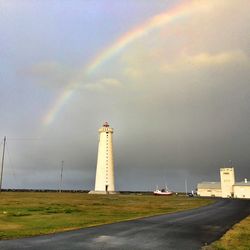 Scenic view of rainbow over lighthouse against sky