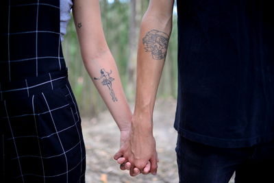 Midsection of couple holding hands