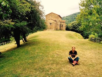 Person in field by old house