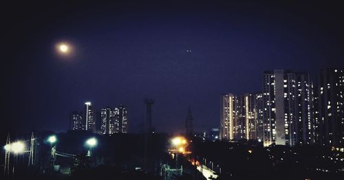 Illuminated cityscape against sky at night