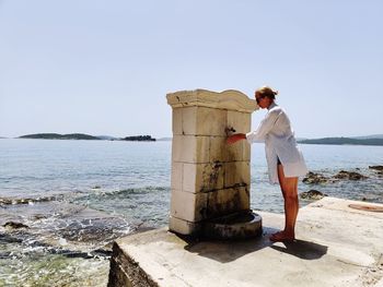 Man standing by sea against clear sky