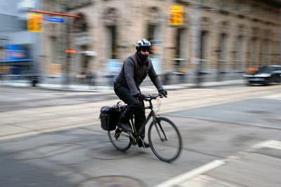 Man riding bicycle on street in city