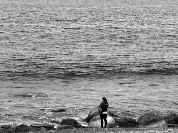 Rear view of women standing at beach