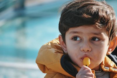 Close-up of cute boy eating lollipop