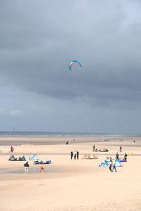 People enjoying at beach against sky