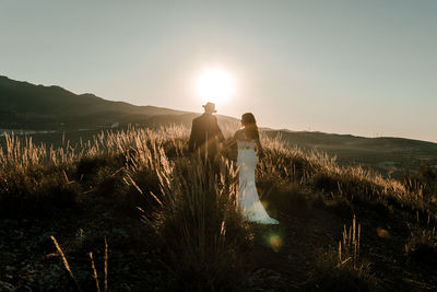 Couple in a field at sunset among dry plants. wedding concept