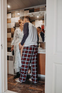 Rear view of people standing against door