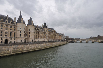 Bridge over river against cloudy sky