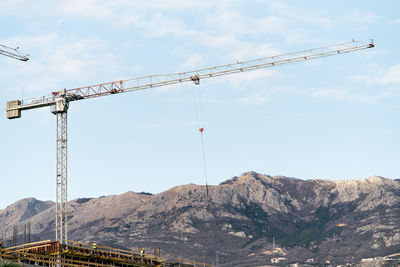 Cranes at construction site against sky