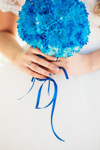 Midsection of bride holding bouquet