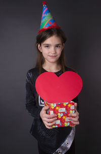 Portrait of smiling girl standing against wall