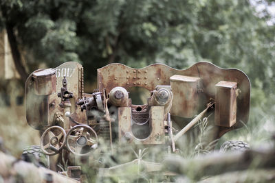 Close-up of old machine part on field