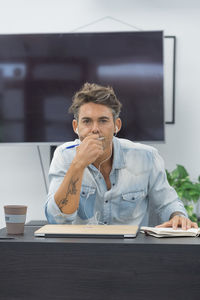 Portrait of a focused man sitting at desktop in modern office