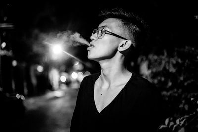 Teenage boy smoking cigarette at night