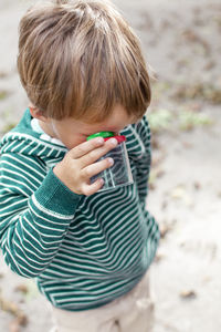 High angle view of boy looking through bottle