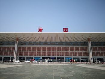 Information sign against clear blue sky in city