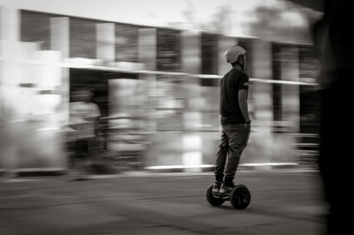 Blurred motion of man riding electric unicycle on street