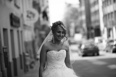 Portrait of smiling young woman standing on street