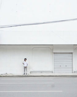 Man standing by window of building