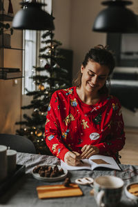 Smiling woman at table preparing for christmas