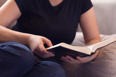 Midsection of woman reading book