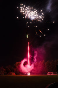 Low angle view of firework display at night