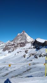 Scenic view of snowcapped mountains against clear blue sky