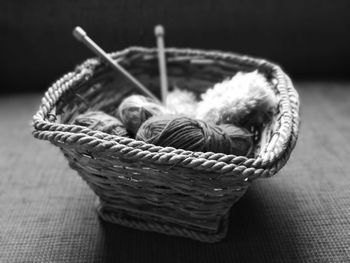 Close-up of thread spools in wicker basket on table