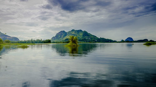 Scenic view of lake by mountain against sky